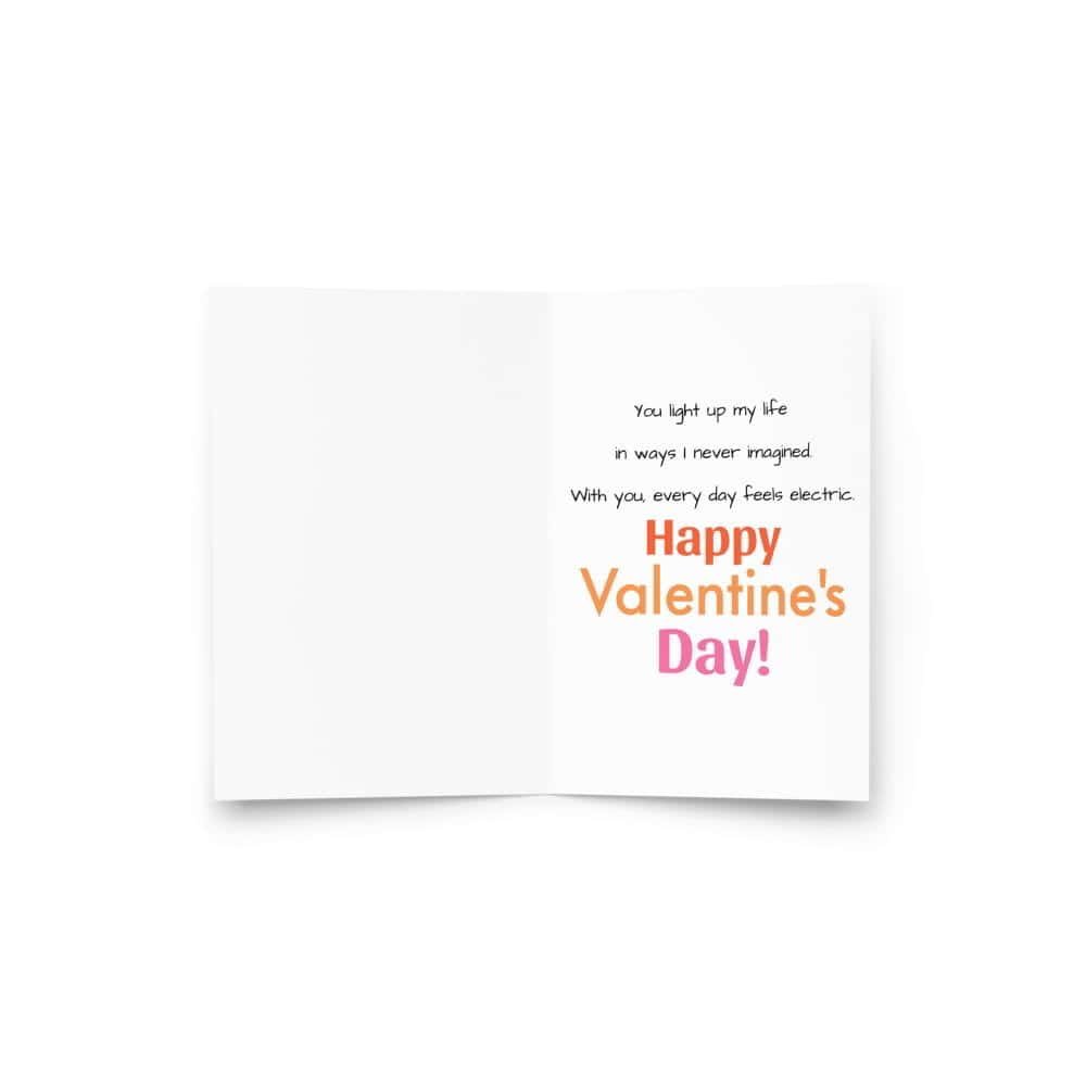 An open Valentine's Day card with a heartfelt message: "You light up my life in ways I never imagined. With you, every day feels electric. Happy Valentine’s Day!" in a mix of black and colorful text.