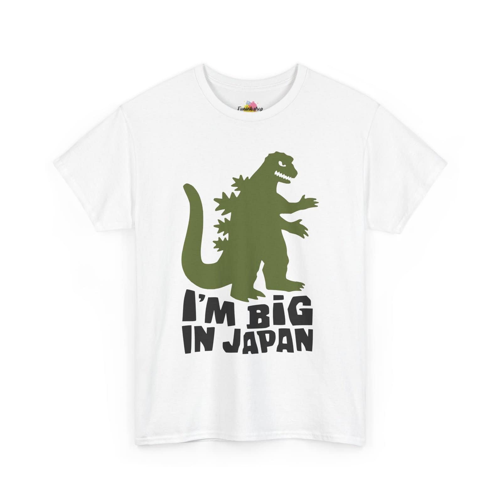 A fun and quirky "I'm Big in Japan" t-shirt featuring a green kaiju (Godzilla-style monster) silhouette with bold black text. Available in multiple colors, including light blue, neon green, gray, and white.