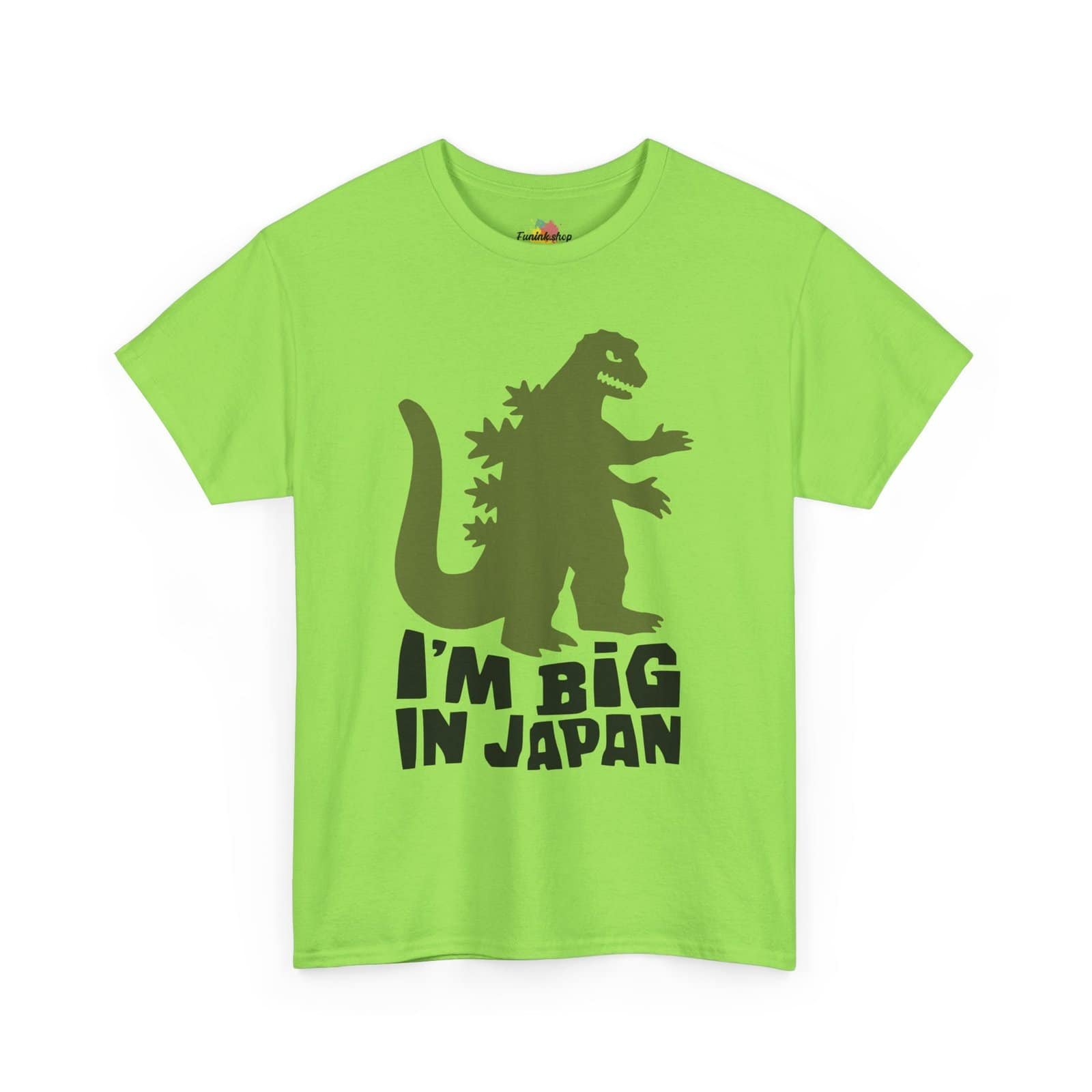 A fun and quirky "I'm Big in Japan" t-shirt featuring a green kaiju (Godzilla-style monster) silhouette with bold black text. Available in multiple colors, including light blue, neon green, gray, and white.
