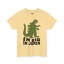 A beige t-shirt featuring a green dinosaur silhouette with the phrase "I'm Big in Japan" written in bold, black letters.
