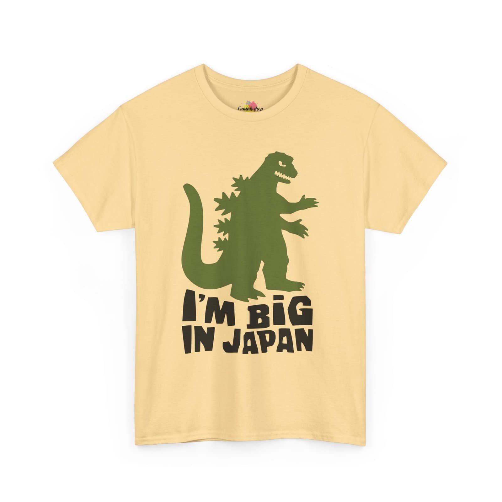 A beige t-shirt featuring a green dinosaur silhouette with the phrase "I'm Big in Japan" written in bold, black letters.
