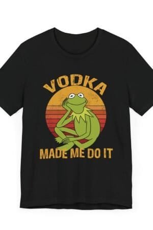 A dark-colored t-shirt featuring a retro-style design with a relaxed green frog and the phrase 'Vodka Made Me Do It'."